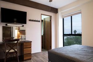 um quarto com uma cama e uma secretária com um espelho em Cerca de UANL, equipado y lujoso en Tulancingo 10 em Monterrey