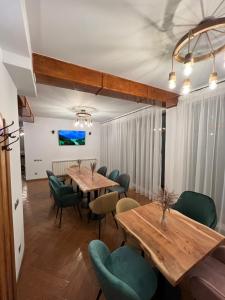 a dining room with wooden tables and green chairs at Chesa Montana in Ranca