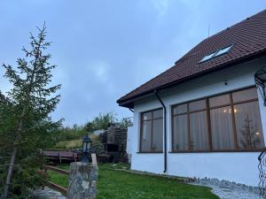 a white house with large sliding glass windows at Chesa Montana in Ranca