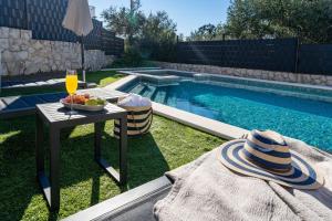 a table with a bowl of fruit next to a swimming pool at Villa Moreta with heated pool, Sauna, Hot-tub in Trogir