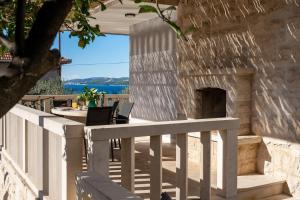 a stone patio with a table and a fireplace at Villa Moreta with heated pool, Sauna, Hot-tub in Trogir +35 photos