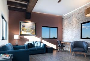 uma sala de estar com um sofá azul e uma parede de tijolos em Cerca de UANL, equipado y lujoso en Tulancingo 10 em Monterrey