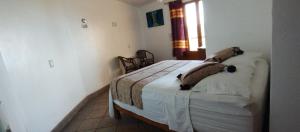 a bedroom with a bed with two animals on it at Cabañas Telayú in Mazunte