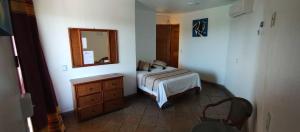 a bedroom with a bed and a dresser and a mirror at Caba&ntilde;as Telay&uacute; in Mazunte