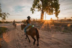 duas pessoas a andar a cavalo por uma estrada de terra em Carmelo Resort & Spa em Carmelo