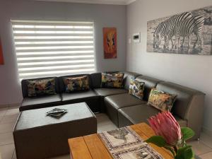 ein Wohnzimmer mit einem Sofa und einem Zebra-Gemälde in der Unterkunft Rhino House with 3 bedrooms next to Pilanesberg and Sun City in Mogwase