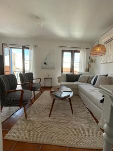 a living room with a white couch and a table at The Doll’s House in Tavira