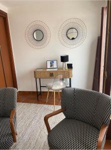 a living room with a desk and two mirrors at The Doll’s House in Tavira