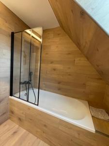 a bath tub in a room with a wooden wall at Le 6B in Hoenheim