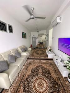 uma sala de estar com um sofá e uma televisão em SKF Homestay em Puchong