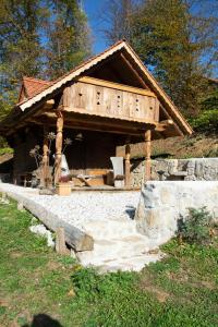 una cabaña de madera con una pasarela de piedra delante de ella en Apartma kašča, en Domžale