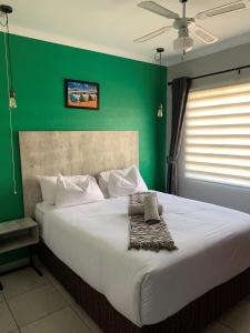 ein Schlafzimmer mit einem großen Bett und einer grünen Wand in der Unterkunft Rhino House with 3 bedrooms next to Pilanesberg and Sun City in Mogwase