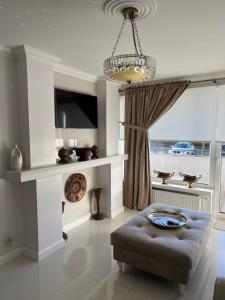 a living room with a couch and a chandelier at Apartament Parys Gold in Malbork