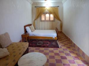 a room with a bed and a couch and a window at berber desert home for rent in Merzouga