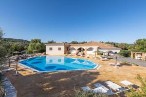 a large swimming pool in front of a house at Villa Antonina in Porto Rotondo