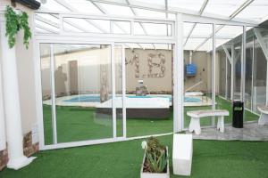 a room with a pool and a patio with green grass at Apart M.B in Pigüé