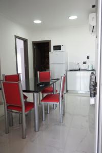 een keuken met een zwarte tafel en rode stoelen bij Apart M.B in Pigüé