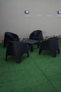 un grupo de sillas y mesas sobre césped verde en Apart M.B en 