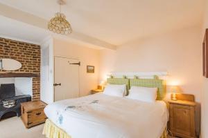a bedroom with a large bed and a brick wall at Lighthouse Cottage in Deal
