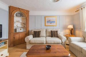 a living room with a couch and a table at Lighthouse Cottage in Deal