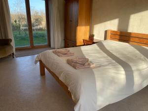 a bedroom with a large bed with towels on it at Shortlake Cottage in Osmington