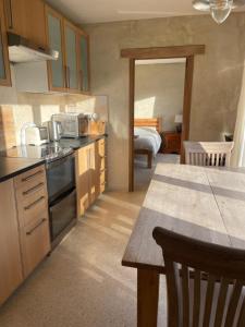 a kitchen with a sink and a table in a room at Shortlake Cottage in Osmington
