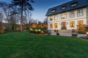 a large house with a green lawn in front of it at Hotel Design Villa Ottilienruh in Ilsenburg
