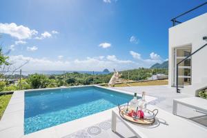 uma piscina numa villa com vista para o oceano em Villa EROS, pour séjour en amoureux, piscine privée, vue mer incroyable em Le Diamant