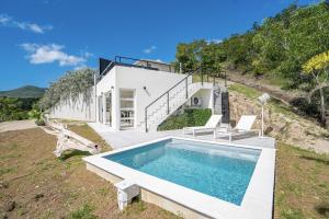 uma casa com piscina numa colina em Villa EROS, pour séjour en amoureux, piscine privée, vue mer incroyable em Le Diamant