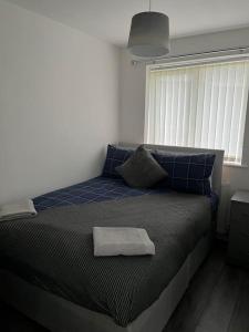 ein Schlafzimmer mit einem Bett und einem Handtuch darauf in der Unterkunft Woolfall House in Roby
