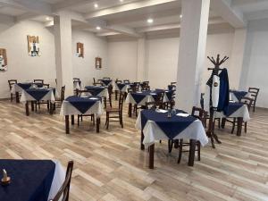 uma sala de jantar com mesas e cadeiras com roupa de cama azul em Villaggio Turistico Europeo em Catânia