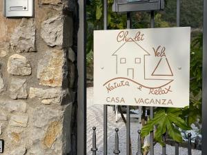 ein Schild für ein Haus an einer Steinmauer in der Unterkunft CHALET VELA Natura e Relax in Gavardo