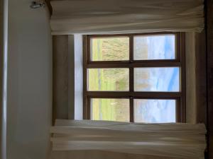 a window in a room with a bed in front of it at Shortlake Cottage in Osmington