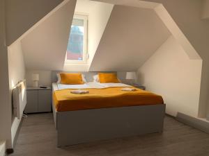 een slaapkamer met een bed met oranje lakens en een raam bij Apartment Grey in Sarajevo