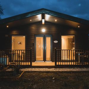 uma casa com uma porta da frente à noite em Broadford Lodges Skye em Broadford