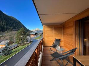 a balcony with two chairs and a table and a view at Quintessence - Apt A201 - BO Immobilier in Châtel