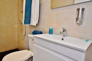a bathroom with a white sink and a toilet at Vallettastay- Lucky Star Penthouse 501 in Valletta