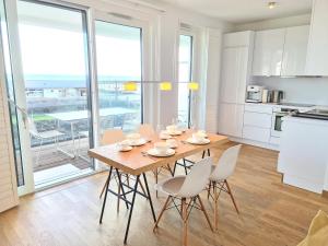 - une cuisine et une salle à manger avec une table et des chaises dans l'établissement Am Hohen Ufer Whg 5, à Grömitz