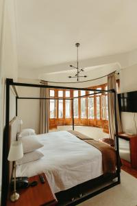 a bedroom with a large white bed with windows at Plaza Central in Arequipa