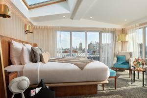 a bedroom with a bed and a large window at Maison Albar - Le Pont-Neuf in Paris