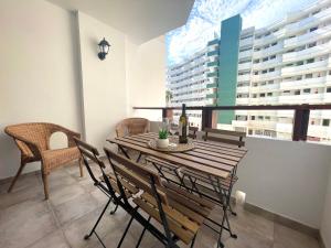 uma mesa de madeira e cadeiras num quarto com uma janela em Timeless clock Apartment em San Bartolomé