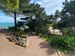 un camino que conduce a una playa con árboles y el océano en LUXURY 2 BEDS APARTMENT BY THE SEA en Bournemouth