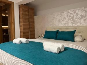 a bedroom with a large bed with towels on it at Apartmani Tesla in Soko Banja