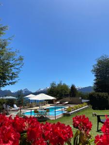 拉安戈斯图拉镇阿科尔曼山林小屋的一个带游泳池和红花的度假胜地