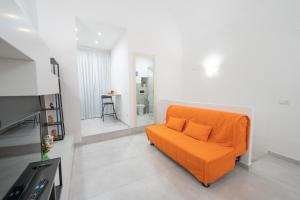 um sofá laranja sentado numa sala de estar em Vico Amico by Dimorra em Nápoles