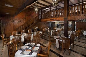 a dining room with tables and chairs and wooden walls at Melia Sierra Nevada in Sierra Nevada