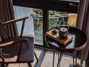 ダナンにあるWings Houseのテーブル、お茶ポット、椅子