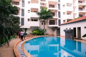 a swimming pool in front of a building at Guesture Stays - Dwellington, Electronics City Phase 2 in Bangalore