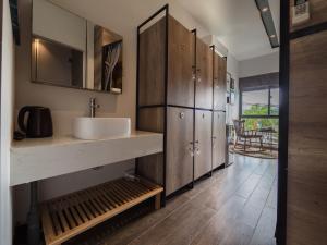 a bathroom with a sink and wooden cabinets at Wings House in Da Nang