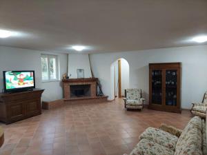 sala de estar con TV, sofá y chimenea en Villa Angela 2 Santa Maria del Molise en Santa Maria del Molise